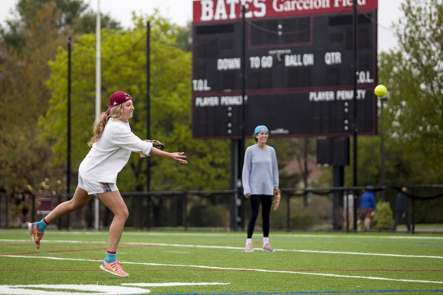 Blair Shrewsbury ‘14 pitches in the 1st annual John Durkin One Swing Softball Tournament on May 17, 2014, on Garcelon Field. Wally Pierce ‘14 looks on, at back. Over 2,000 was raised for the John Nolen Durkin Scholarship Fund. (Sarah Crosby/Bates College)