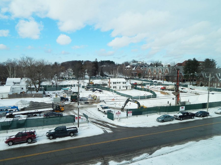 A view of the 65 Campus Ave. construction site from an upper story of Lewiston Middle School on Jan. 9, 2015. At right, the orange boom and the two concrete trucks roughly indicate the placement of the forthcoming student residence. (Doug Hubley/Bates College)