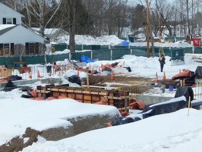 Wall foundation sections for the new student residence at 65 Campus Ave. The red-and-black tarp-like things are blankets that help concrete cure in the cold. (Doug Hubley/Bates College)