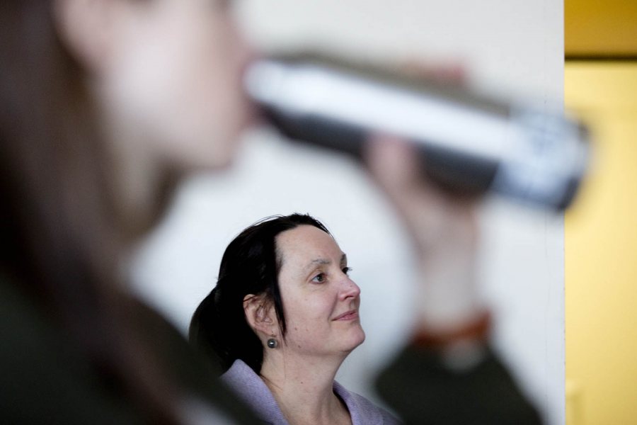 Framed by a student's arm, Associate Professor of English Sylvia Federico listens to Gerry Bigelow discuss archaeology during a class session of Introduction to Classical and Medieval Studies in March 2015. (Phyllis Graber Jensen/Bates College)