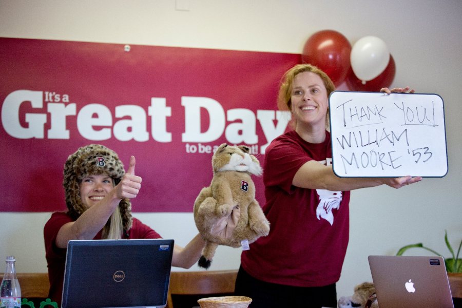 Bates staff thank a Great Day donor during the festive livestream on March 31, 2015. Rocking the bobcat hat at left is Cary Gemmer '07, director of alumni engagement, while Genevieve Leslie, director of Reunion fundraising and programming, holds the thank-you to donor William Moore '53. (Phyllis Graber Jensen/Bates College)