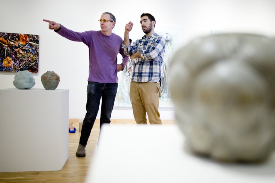 Robert Feintuch and Teddy Poneman '15, an art and visual culture major from Larchmont, N.Y., discuss the placement of Poneman’s stoneware in the Bates College Museum of Art for the opening for the Senior Thesis Exhibition. Feintuch, a painter and senior lecturer, works with thesis students. (Phyllis Graber Jensen/Bates College)