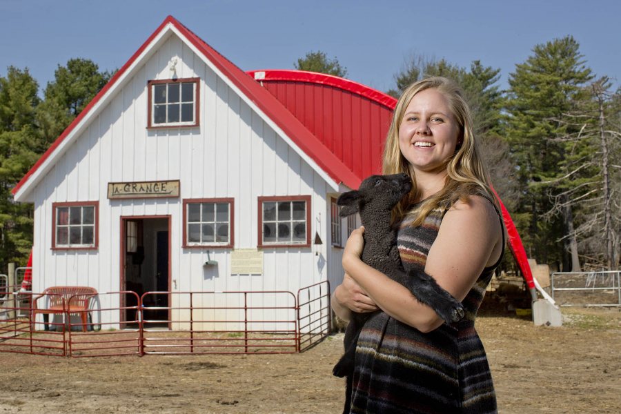 Environmental major and Watson Fellow Caroline Caldwell '15 of Gambier, Ohio, poses with a friendly kid at Nezinscot Farm in Turner, Maine. (Phyllis Graber Jensen/Bates College)