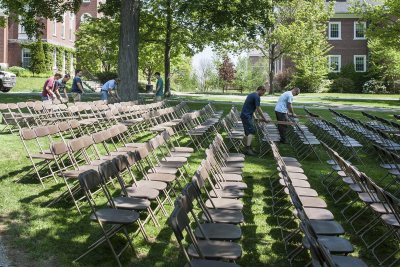 Facility Services workers use boards to set the  proper distance between rows of Commencement 2015 seating. (Josh Kuckens/Bates College)