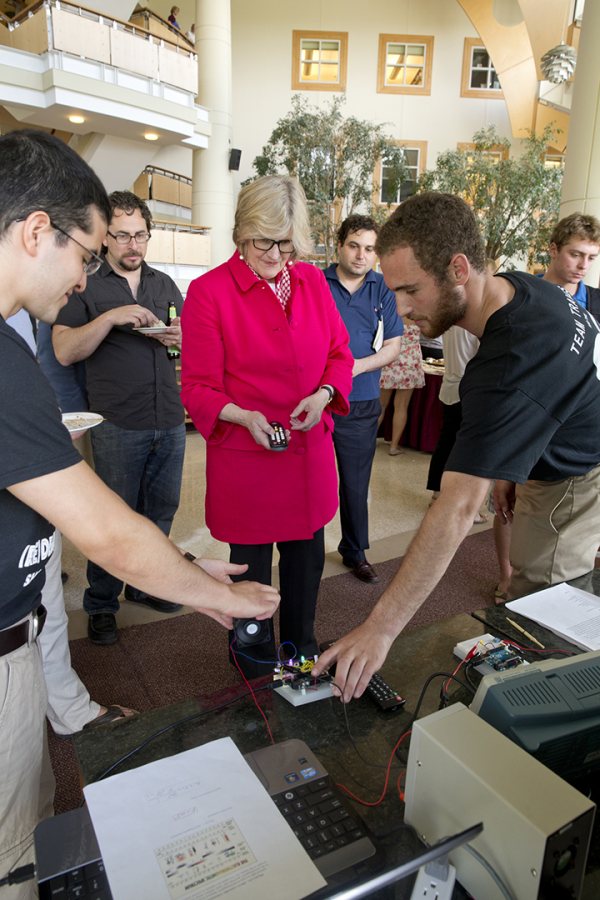 Students in physics professor Travis Gould's microcontroller laboratory give Bates President Clayton Spencer a chance to technology they adapted for a lab project in physics professor Travis Gould's microcontroller laboratory. (Phyllis Graber Jensen/Bates College)