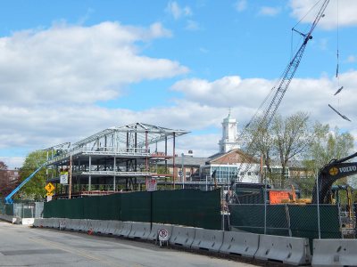 With a "Christmas tree" -- multiple pieces of steel in one lift -- dangling from the crane, the framework of 65 Campus Ave. is shown from the west on May 13, 2015. (Doug Hubley/Bates College)