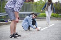 Theresa Seel '18 of Darmstadt, Germany, helps classmates put down lines for a demonstration bike lane on Oxford Street in Lewiston on May 20. The project was part of a Short Term urban planning course taught by Mike Lydon '04. (Josh Kuckens/Bates College)