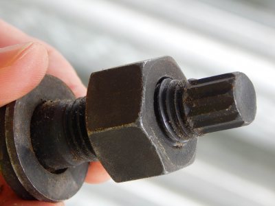 A tension-control bolt, with nut. As the fastening is tightened, the ribbed piece at right snaps off the bolt when the proper tension is reached. (Doug Hubley/Bates College)