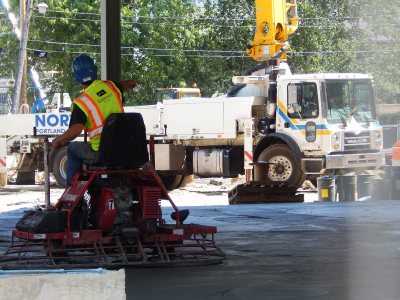 Concrete reality: More fun with the ride-on trowel -- one of three that were smoothing fresh concrete on the ground floor of 55 Campus Ave. on July 16, 2015. (Doug Hubley/Bates College)