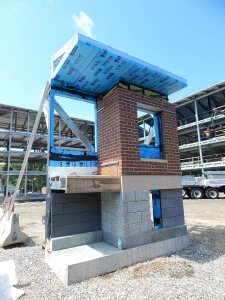 Situated near the street at the 55 Campus Ave. work site, this mockup shows the surface treatments planned for the Campus Life dorms. Along with the brick are granite and high-performance Taktl concrete panels, at lower left. (Doug Hubley/Bates College)