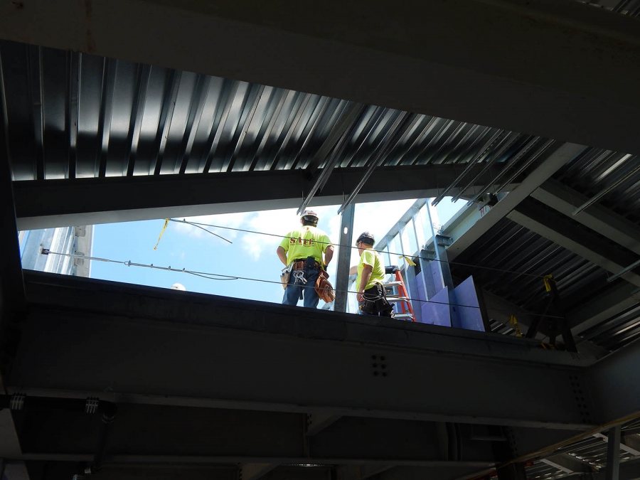 Construction supervisors stand in the future "mechanical well," where air handling gear will be located, at 65 Campus Ave. on July 28, 2015. (Doug Hubley/Bates College)