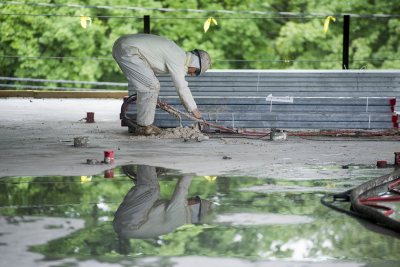 A fireproofing technician adjusts his applicator at 65 Campus Ave. on July 1, 2015. (Josh Kuckens/Bates College)