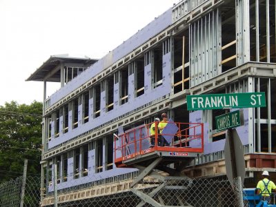 Workers install wallboard at the new student residence at 65 Campus Ave. on July 9, 2015. (Doug Hubley/Bates College)