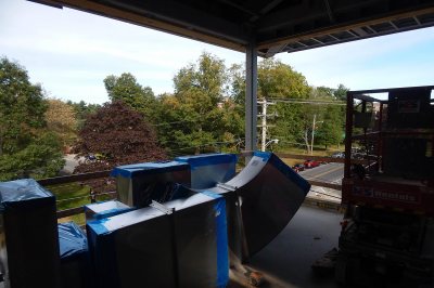 Ducts in a row: Seen past a stockpile of air ducts on the fourth floor of 65 Campus Ave., the trees at Central and Campus avenues are just starting to turn on Sept. 21, 2015. (Doug Hubley/Bates College)