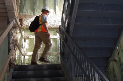 Chris Streifel, Facility Services project manager for the Campus Avenue dorm construction, climbs stairs at No. 65 on Sept. 21, 2015. (Doug Hubley/Bates College)