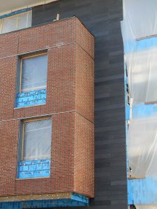 This image taken Oct. 20, 2015, shows contrasting masonry surfaces on a west wall of 65 Campus Ave.: brick and the rugged concrete paneling called Taktl. (Doug Hubley/Bates College)