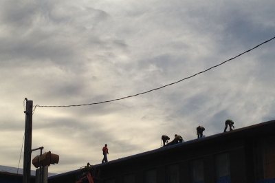 Workers for Industrial Roofing atop 65 Campus Ave. on Nov. 10, 2015. (Doug Hubley/Bates College)