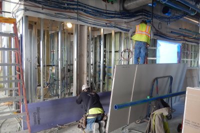 A drywall installer and an electrician fit out the fourth floor of 55 Campus Ave. on Dec. 1, 2015. (Doug Hubley/Bates College) 