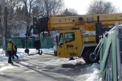 Having hoisted HVAC equipment to the roofs of both new student residences, a Cote Crane & Rigging telescopic crane pulls onto Franklin Street on its way back to Auburn on Jan. 7, 2016. (Doug Hubley/Bates College) 