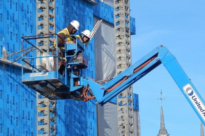 Two attentive workers and some indifferent metal channels ride a lift at 565 Campus Ave. on Jan. 7, 2016. (Doug Hubley/Bates College) 