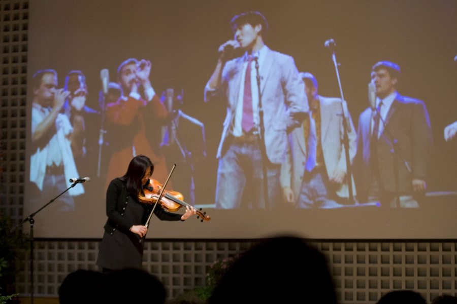 A projected image shows the late James Jhun '16 singing with his a cappella group as So Hee Ki '16 performs a work by Bach during the celebration of his life on Jan. 22. (Phyllis Graber Jensen/Bates 