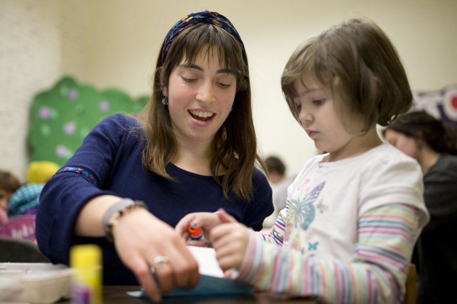 Alisa Amador ’18 of Cambridge, Mass., works with a budding author on designing a chapter book at the Lewiston Public Library. Amador volunteers with the mobile Art Van for area children. (Phyllis Graber Jensen/Bates College)