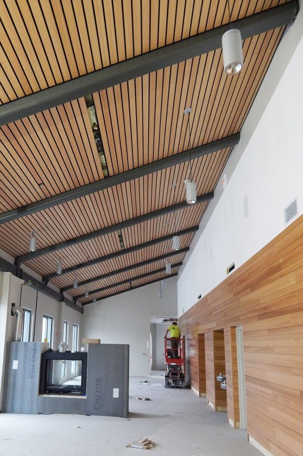 An electrician hangs light fixtures in the "Treehouse," the fourth-floor rec room at 65 Campus Ave., on Feb. 16, 2016. (Doug Hubley/Bates College) 