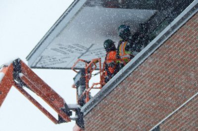 Sheetmetal fitters for Industrial Roofing Company work on a 55 Campus Ave. soffit during a snowfall on March 21, 2016. During a (Doug Hubley/Bates College) 