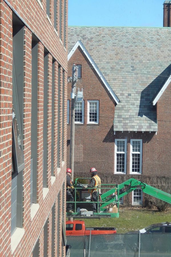 Workers on a lift at 55 Campus Ave. on March 22, 2016. (Doug Hubley/Bates College) 