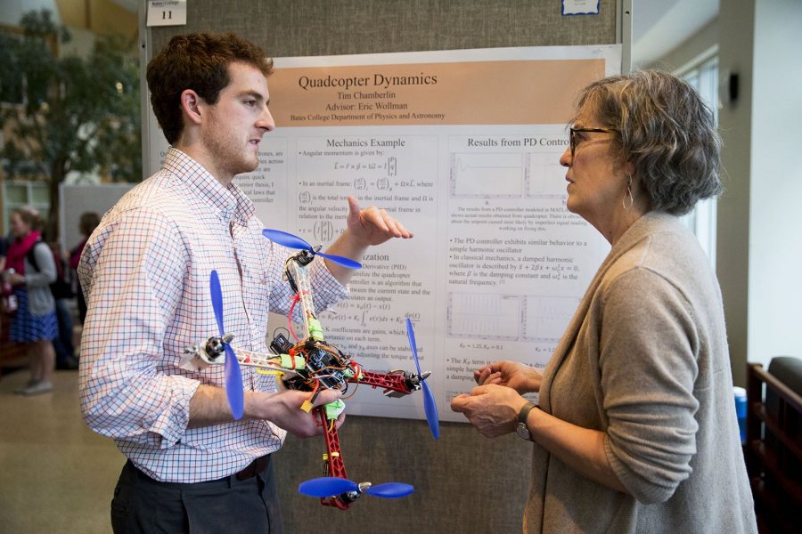 Tim Chamberlin '16 of Norwich, Vt., explains the physics behind drone flight to a listener who probably won't take flight: his mom, Kate Emlen. (Phyllis Graber Jensen/Bates College)