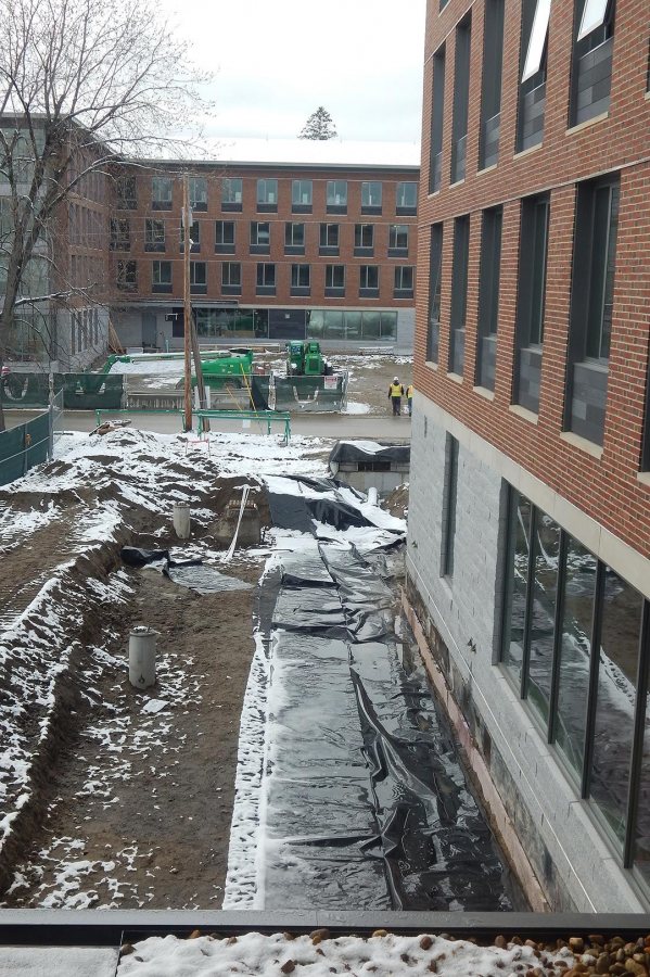 A rain garden seen from the second floor of 65 Campus Ave. on April 26, 2016. The plastic sheeting will divert runoff away from the foundation. The concrete cylinders at left are bases for light poles. (Doug Hubley/Bates College) 