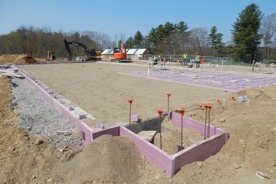 The site of Bates' new boathouse is nearly ready for its foundation slab. The pinkish material is insulation. In the far distance past the yellow excavator is Campus Construction Update's radar-equipped van. (Doug Hubley/Bates College