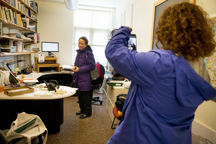 Tourse's' fact-finding visit included doumenting people in their campus spaces. Here, she videos Associate Professor of Politics Leslie Hill in her Pettengill Hall office. (Phyllis Graber Jensen/Bates College)