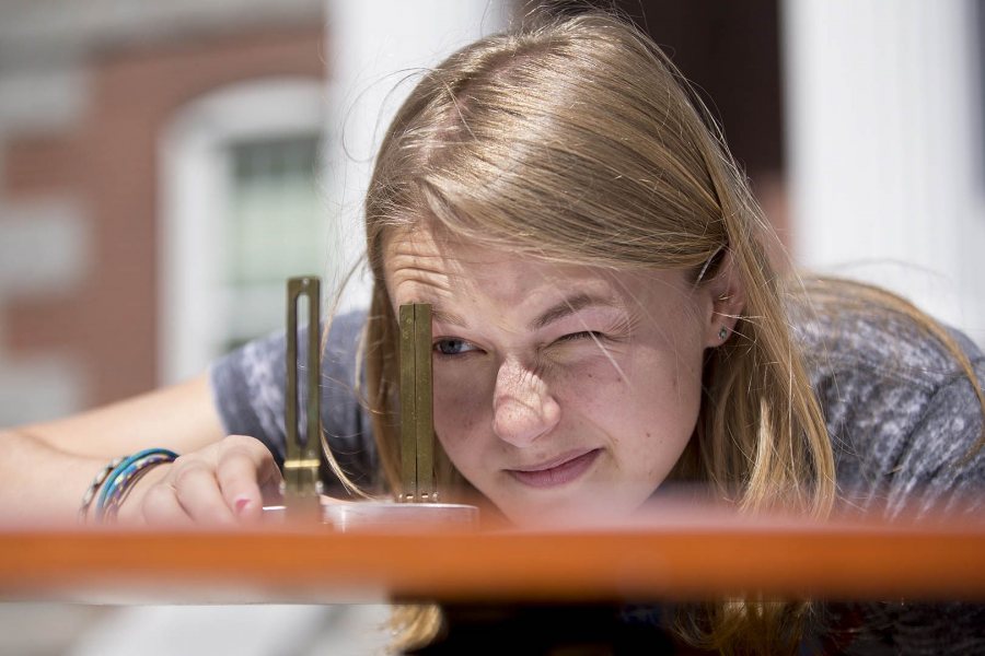 A member of the "Innovations in Mapping" class, Haley Crim '19 of Sandy Spring, Md., uses a surveyor's compass to determine an angle during a triangulation exercise on May 6, 2016. (Phyllis Graber Jensen/Bates College)