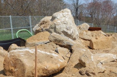 Bowled over by boulders: Discovered underground at the site of Bates' new boathouse, these rocks took the construction team by surprise. (Doug Hubley/Bates College) 