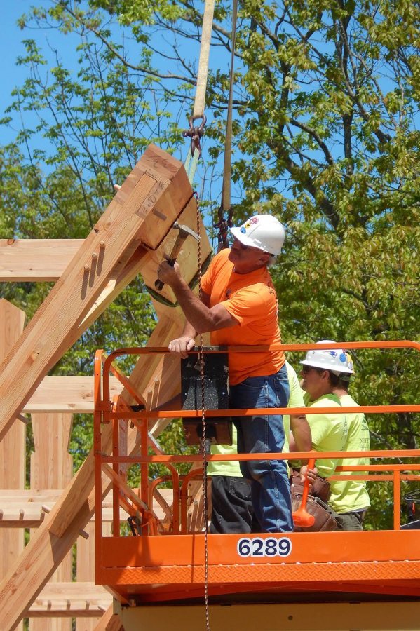 A timber framer for South County Post & Beam drives in a peg on the boathouse on May 26, 2016. (Doug Hubley/Bates College) 