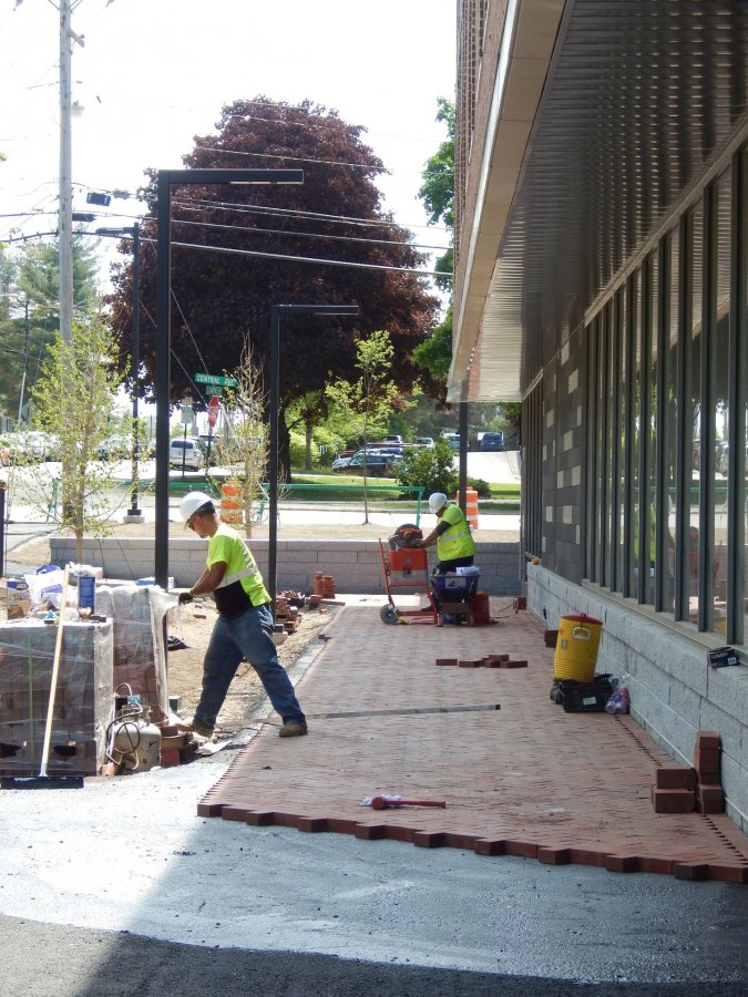 A new brick walkway at 65 Campus Ave. on May 31, 2016. The shiny stuff in the foreground is Karnak -- no relation to Johnny Carson, it's a sticky dilution of asphalt used to hold bricks in place. (Doug Hubley/Bates College)