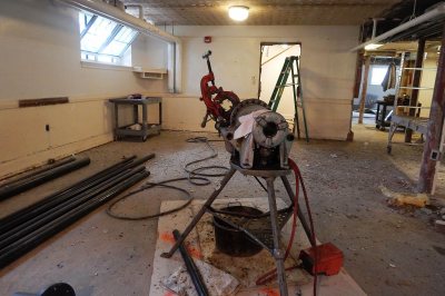 A game and lounge area will go into this basement space in Smith Hall, shown on June 8, 2016. The device at center is a pipe cutter. (Doug Hubley/Bates College)