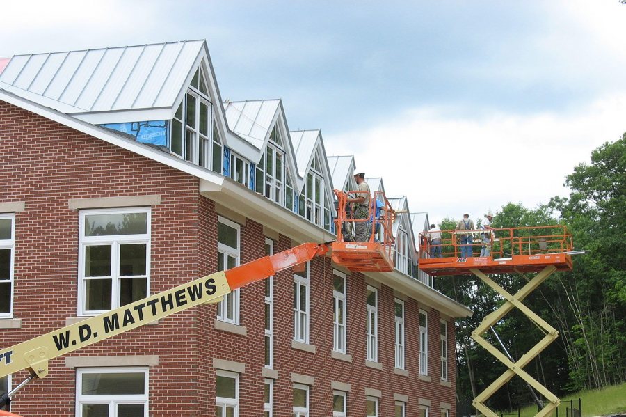 Wizards of oxide: Workers finish the gray-oxidized roofing on the west side of the new student housing. (Doug Hubley/Bates College)