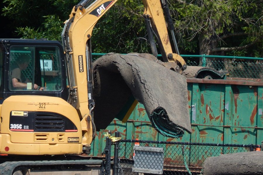 A Crooker Construction excavator handles rolls of AstroTurf that have been removed from Campus Avenue Field. GreenFields TX will replace the 16-year-old AstroTurf. (Doug Hubley/Bates College)