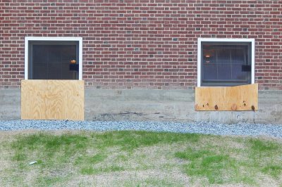 The plywood is covering openings where wall material was removed to enlarge the windows on the back side of Smith Hall. (Doug Hubley/Bates College)