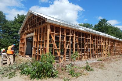 Carpenters for R.S. Egenstafer Construction of Littleton, Maine, dismantling the old Bates boathouse on July 19, 2016. (Doug Hubley/Bates College) 
