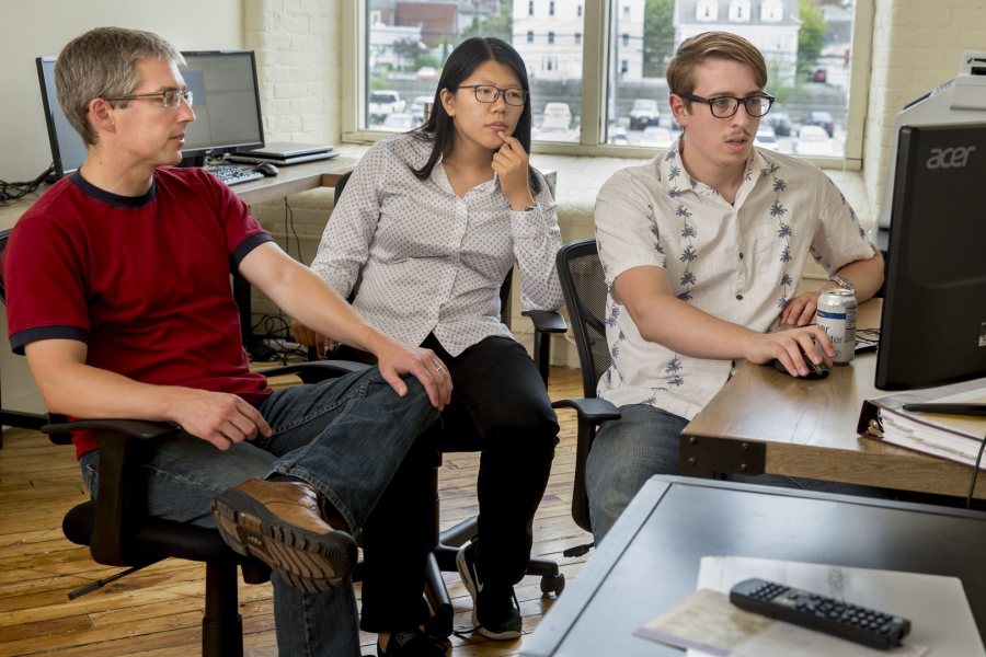 From left, Associate Professor of Economics Nathan Tefft meets with his Purposeful Work interns Fan Dong ’17 of Beijing and Michael Varner ’17 of Chelsea, Mich, in the offices of Looking Glass Investments in the Fort Andross Mill in Brunswick. Tefft is executive vice president and chief economist for LGI, a firm that invests in peer-to-peer lending. (Phyllis Graber Jensen/Bates College)