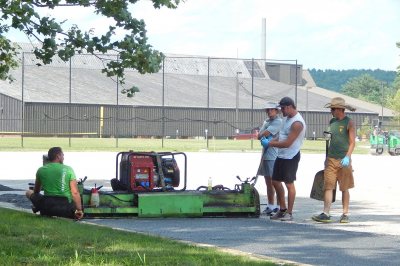 A crew for NET Sports of Saco, Maine, places the GreenFields TX Ecocept layer on Bates' field hockey facility. (Doug Hubley/Bates College) 