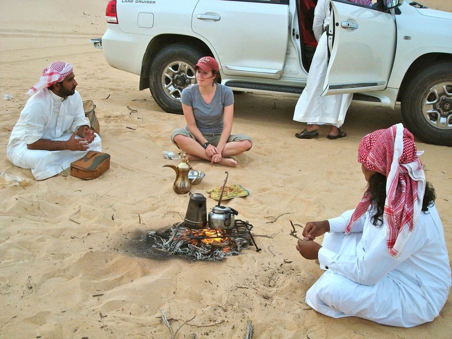 During the 2012 Short Term to Saudi Arabia, anthropology major Devin Tatro '14 talks with Saudi men during an outing to a desert farm in the Eastern Province. At the gathering, the Bates women got permission not to wear their abayas. (Photograph by Ana Bisaillon ’12)