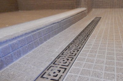 In the new and improved Smith Hall showers, fancy metalwork decorates the drain troughs and a tiled barrier ensures that bathers don't have to stand in each others' runoff. (Doug Hubley/Bates College)