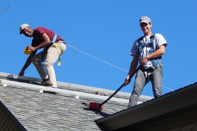 Ahmed Sheikh '19 and Brent Feldman '19 are preparing to install power optimizers for the Shortridge solar-electric array. (Doug Hubley/Bates College) 