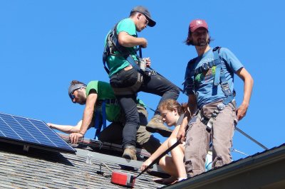 A PV panel installation squad: from left, George Fiske '19, Aston Ireland of ReVision Energy, Katharine Gaillard '19, sustainability manager Tom Twist. (Doug Hubley/Bates College) 