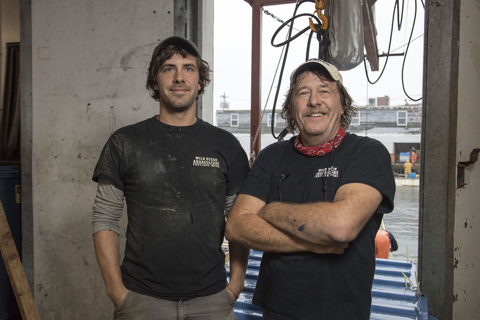 Matt Moretti '06 and his father, Gary Moretti, pose for a portrait at the Bangs Island Mussels processing facility on the Portland waterfront.