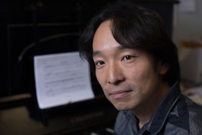 Hiroya Miura, associate professor of music st Bates, is shown in his Olin Arts Center office shortly before he attended a contemporary-music festival in Cuba. (Phyllis Graber Jensen/Bates College)